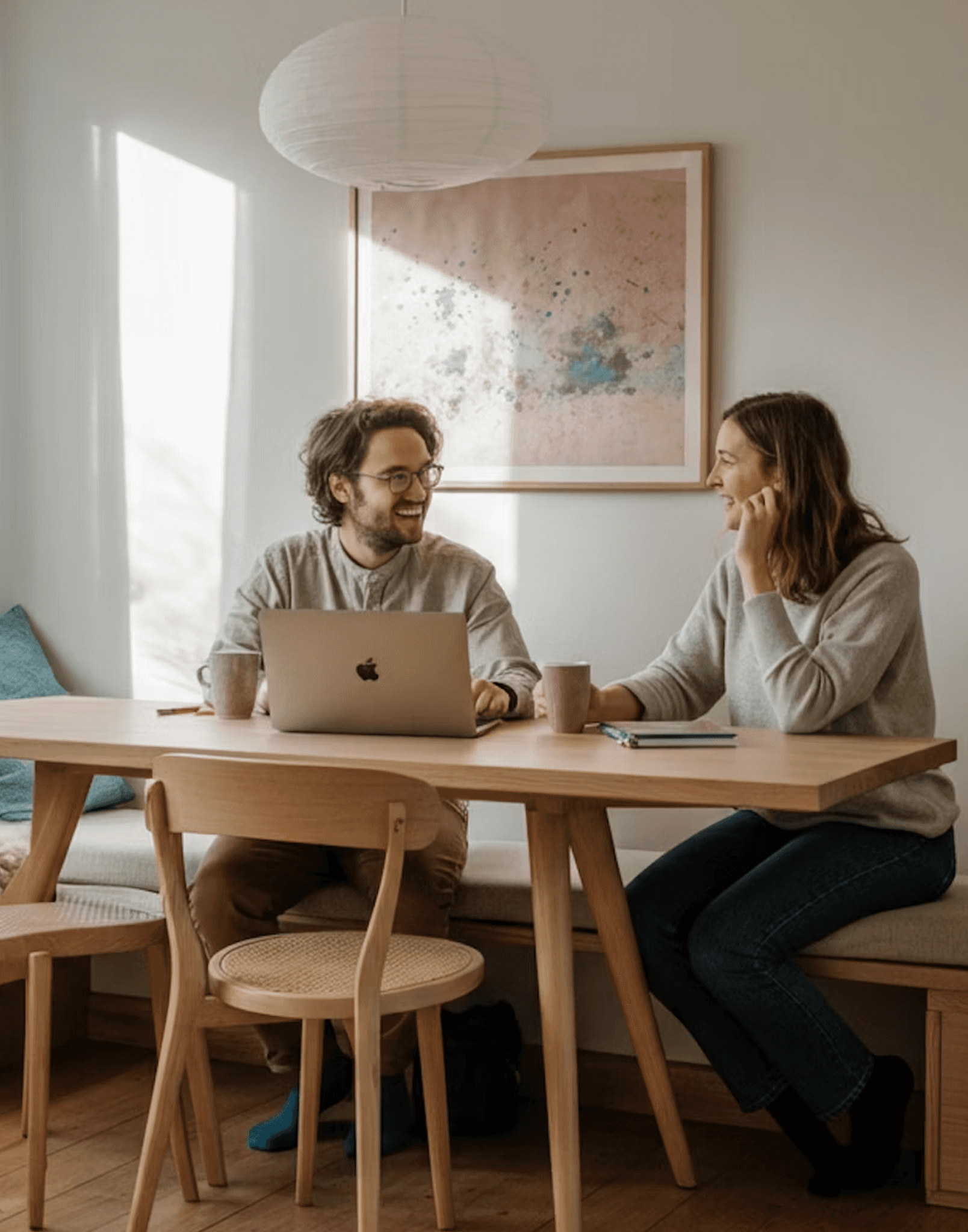 Two people reviewing work together at a table